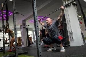 Athlet führt eine Langhantelübung im Ausfallschritt im Friendship Gym Hamburg aus.